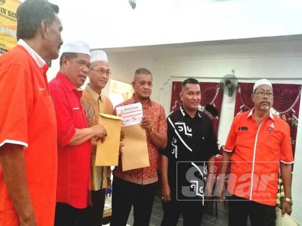 Kamarudin (tiga dari kanan) menyerahkan borang keahlian ahli Amanah Kubur Datu kepada Presiden, Mohamad Sabu sempena kehadiran pemimpin berkenaan pada majlis perasmian Mesyuarat Agung Tahunan Kali Ke-3 Amanah Jeli baru-baru ini.