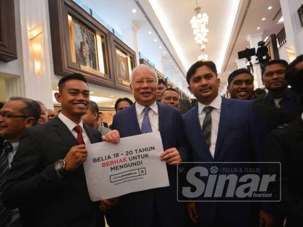 Bekas Perdana Menteri yang juga Ahli Parlimen Pekan, Datuk Seri Najib Abdul Razak memegang poster had umur mengundi di lobi Parlimen di sini hari ini. - Foto SHARIFUDIN ABDUL RAHIM