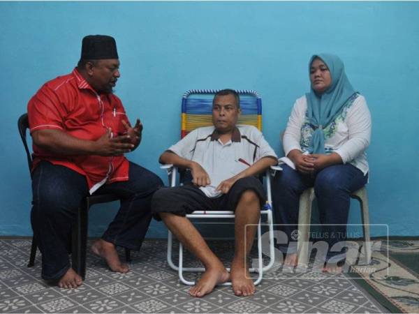 Norhisham (tengah) bersama isterinya sewaktu menerima kunjungan Mohd Hamidi.