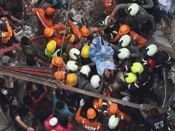 Anggota penyelamat membawa keluar mangsa yang selamat susulan bangunan runtuh di Dongri, India. - Foto AFP