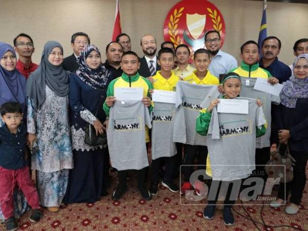 Mukhriz (tengah) bergambar bersama pemain cilik Kedah selepas menyerahkan sumbangan sebelum pasukan itu berangkat ke Barcelona.