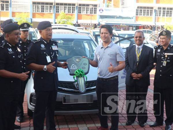 Zainuddin (dua, kiri) menerima replika kunci kereta daripada wakil Spanco, Norazmi Abd Sani di Dataran Kawad, Ibu Pejabat Polis Kontinjen (IPK) Kedah, di sini hari ini.