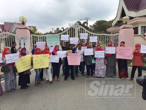 Sebahagian penduduk dan ahli Umno Serkam yang mengadakan demo bantahan terhadap Exco tersebut di hadapan pintu masuk Seri Negeri, Ayer Keroh, di sini, hari ini.