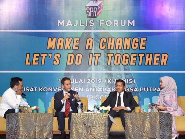 Pengerusi Suruhanjaya Pilihan Raya (SPR) Azhar Azizan Harun (dua, kiri) bercakap sebagai salah seorang ahli panel pada forum 'Make A Change, Let’s Do It Together' di Pusat Konvensyen Antarabangsa Putrajaya hari ini. - Foto BERNAMA