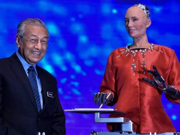 Reaksi Perdana Menteri Tun Dr Mahathir Mohamad ketika berinteraksi dengan Sophia, robot humanoid sosial yang dikuasakan dengan kecerdasan buatan teknologi teras Revolusi Industri 4.0 (IR4.0) pada Majlis Perasmian 'Beyond Paradigm Summit 2019' di Pusat Perdagangan dan Pameran Antarabangsa Malaysia (MITEC) semalam. - Foto Bernama