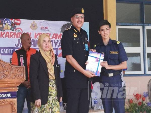 Zulkarnain (dua dari kanan) menyerahkan sijil penghargaan kepada kadet JPJ yang menyertai Karnival Keselamatan Jalan Raya Kadet JPJ Terengganu 2019 semalam.