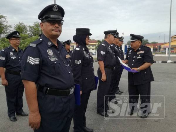 Muhd Nurhishamuddin (kanan) bertanyakan sesuatu kepada salah seorang anggota yang menerima kenaikan pangkat pada majlis tersebut.