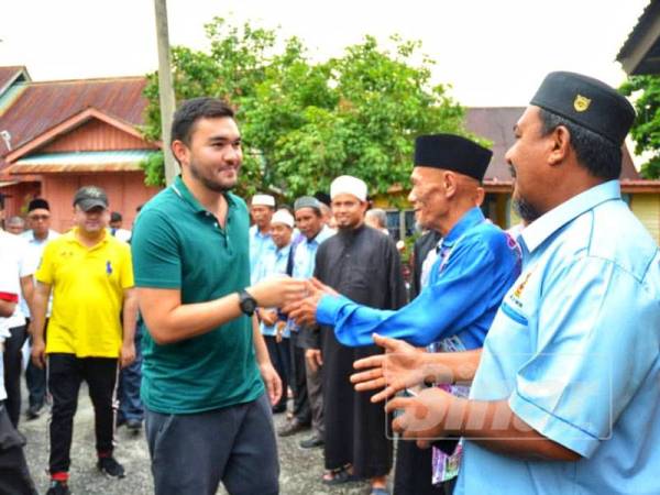 Tengku Amir bersalaman dengan penduduk kampung yang menyambut kedatangannya sewaktu melawat Kampung Changkat dan Kerdas, Rabu lalu.