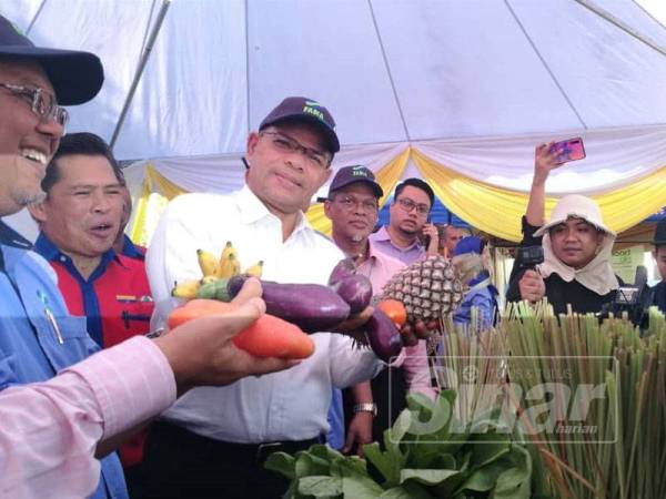 Saifuddin Nasution ketika menunjukkan makanan yang disumbangkan untuk program Food Bank Malaysian di pasar tani Putrajaya di sini hari ini.