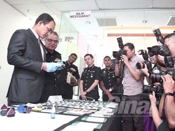 Khairul Dzaimee memegang pasport tiruan pada sidang media di Putrajaya. - Foto Sinar Harian ZAHID IZZANI