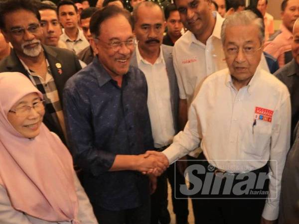 Dr Mahathir bersalaman dengan Anwar ketika menghadiri Majlis Temurapat Pimpinan Keadilan Pusat, di sini malam ini. - Foto Sinar Harian