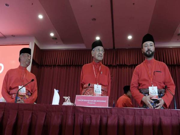 Dr Mahathir (tengah) bersama Tan Sri Muhyiddin Yassin (kiri) dan Datuk Seri Mukhriz Tun Dr Mahathir (kanan) pada Perhimpunan Agung Khas Bersatu, hari ini. - Foto Bernama