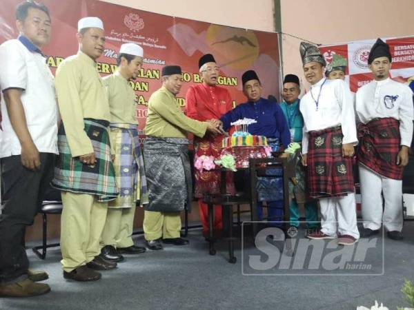 Mahdzir (tengah) bersama Hassan (empat dari kiri) dan Mohd Zain (empat dari kanan) memotong kek pada majlis perasmian Persidangan UMNO Bachok.
