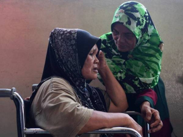 Ibu mangsa Siti Zaleha Adul Rashid, 60, (kanan) dan besannya Noraini Che Ibrahim, 53, sugul ketika di Hospital Tengku Ampuan Afzan (HTAA) selepas anaknya Sharifah Azlina Syed Kassim, 37, dan dua cucunya Muhamad Haikal Hakimi Hairol, 11, dan Muhamad Adam Daniel, 7, maut dalam kebakaran. - FOTO BERNAMA