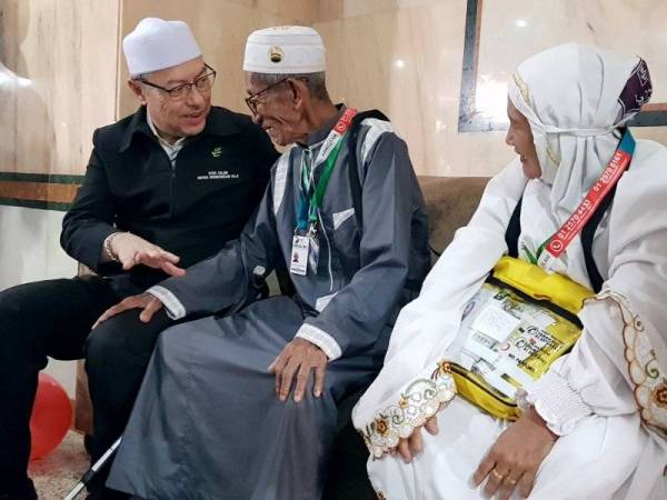 Ketua Rombongan Haji Malaysia Datuk Seri Syed Saleh Syed Abdul Rahman (kiri) beramah mesra dengan Abdul Gapak Mahmud, 101, (tengah) dan isteri Siti Maimun Hassan, 60, pada majlis sambutan hari lahir jemaah haji tertua Malaysia itu di Abraj Janadriyah hari ini. - Foto Bernama