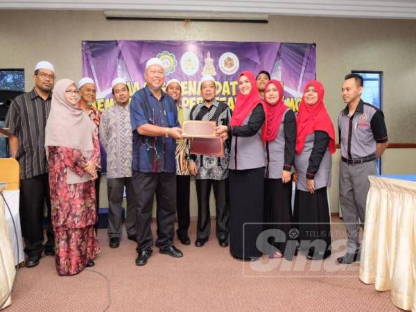 Saiful Azmi (enam dari kiri) dan Mohammad Syukri melihat pertukaran dokumen antara Kohijrah dan Kitab pada majlis menandatangani MoU di KGRP Kerteh.