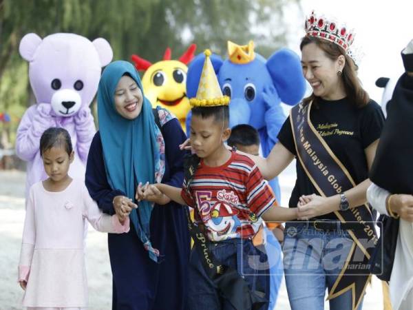 Nor Azimah (dua, kiri) memimpin Muhammad Norfareez sambil dibantu wakil UPF di sambutan hari jadinya.