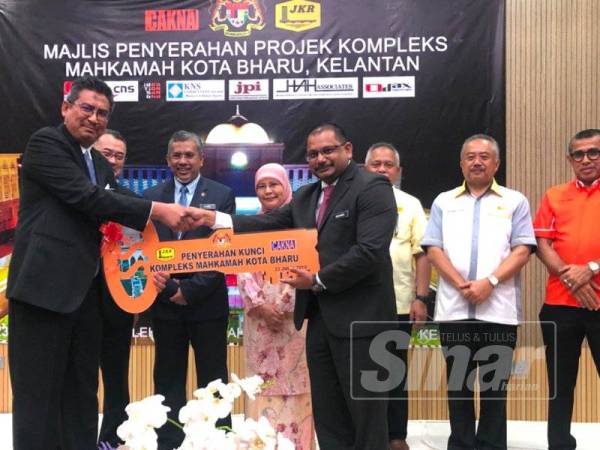 Mohamed Hanipa (dua dari kiri) bersama Tengku Maimun (tiga dari kanan) menyaksikan penyerahan replika kunci sempena Majlis Penyerahan Projek Mahkamah Kota Bharu Kelantan hari ini.