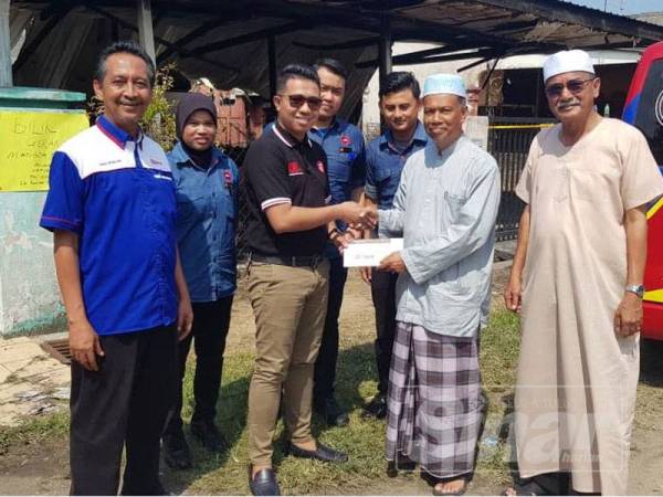 Pengerusi Masjid Al-Falah, Nasuha (dua dari kanan) menerima sumbangan daripada Pengurus Pizza Hut Pahang, Ahmad Lutfi Abdul Malek untuk tabung derma mangsa kebakaran Perkampungan Sungai Isap 2.