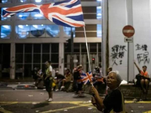 Bendera Britain dikibarkan seorang penunjuk perasaan ketika protes antikerajaan di Hong Kong. - Foto AFP