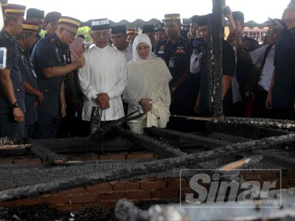 Al-Sultan Abdullah diiringi Raja Permaisuri Agong turut mencemar duli melihat rumah mangsa yang musnah sepenuhnya di Perkampungan Sungai Isap 2 hari ini.