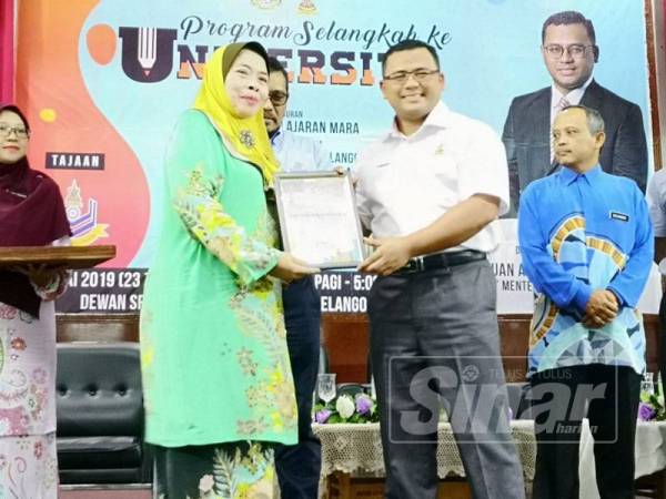 Amirudin menyampaikan cenderhati kepada salah seorang penerima pada Program Selangkah ke Universiti anjuran Yayasan Pelajaran MARA di Dewan Seri Bernam, Sungai Besar hari ini. 