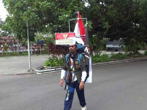 Medi Bastoni berjalan secara mengundur menuju ke Istana Negara di Jakarta dengan harapan dapat bertemu Presiden Jokowi. - Foto Jatimnow.com