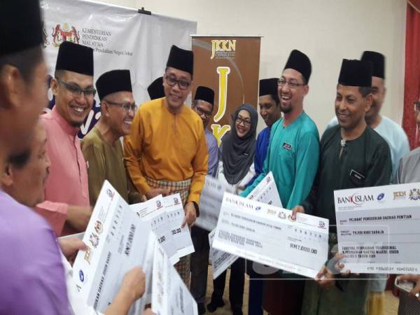 Mohd Khuzzan (tengah) berbual dengan wakil pejabat pendidikan daerah untuk penganjuran Festival Permainan Tradisional dan Permainan Rakyat Negeri Johor ke-5 Tahun 2019 semalam.