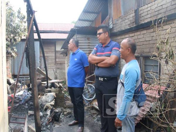 Yusof (kiri) dan Syed Mohd Johan (tengah) melawat kediaman mangsa terbakar di belakang surau Al-Hidayah, Taman Mutiara ,di sini hari ini.
