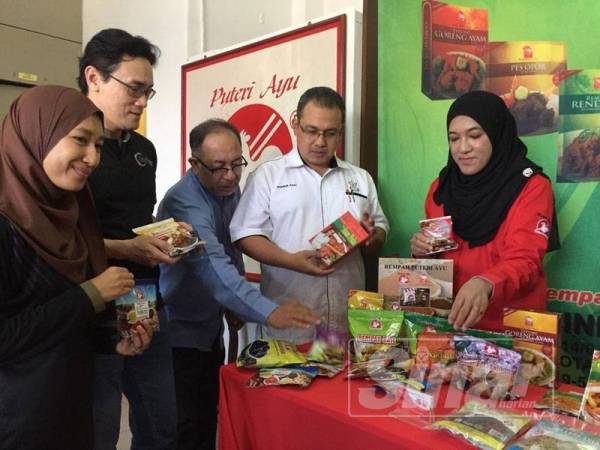 Rizal (dua, kiri) dan Khairur Rizal (dua, kanan) melihat produk dihasilkan PJ Food Industries sempena Program Jejak PKS Wilayah Pantai Timur di Indera Mahkota, hari ini.