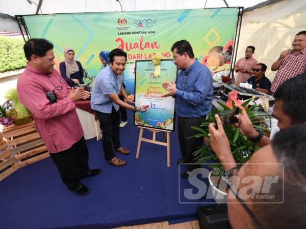 Najwan (tengah) sambil disaksikan Mohemed Zharaubi (kanan) menyempurnakan simbolik perasmian Program JTDL di SACC Mall.