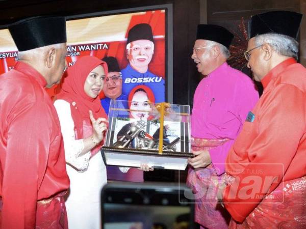 Norliza (dua dari kiri) menyampaikan cenderamata kepada Najib selepas merasmikan Mesyuarat Pergerakan Wanita UMNO Bahagian Bukit Gelugor pagi tadi.