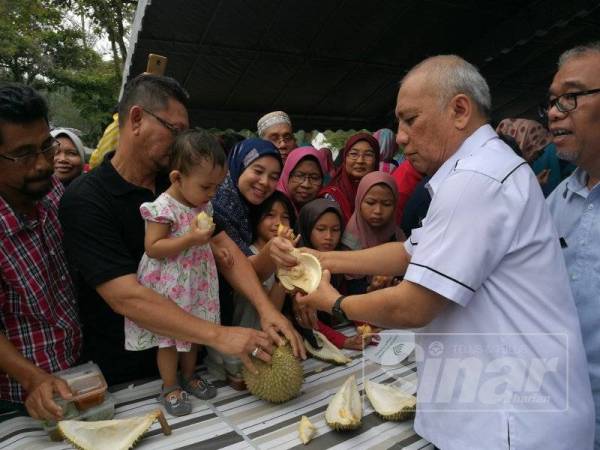 Mohd Soffi menikmati buah durian bersama masyarakat pada Hari Peladang, Penternak dan Nelayan di Taman Bandar, Indera Mahkota hari ini.