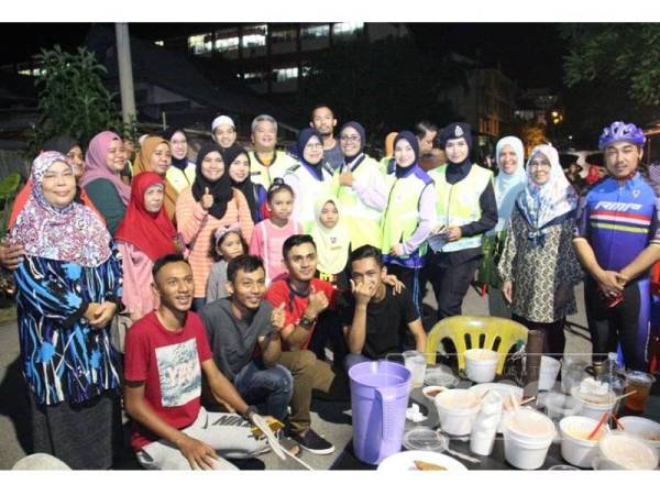 Abdul Rahim (barisan belakang, tengah) merakam gambar bersama sebahagian anggota dan masyarakat setempat yang ditemui sepanjang laluan sempena Program Gateh Cegah Jenayah IPD Kuala Terengganu, semalam.