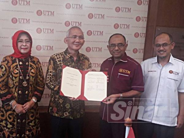 Wahid (dua dari kanan) dan Edi (dua dari kiri) bertukar dokumen MoU yang ditandatangani sambil diperhatikan Tri (kiri) dan Mohammed Rafiq di UTM hari ini.