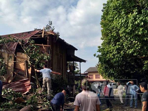 Gotong-royong membersihkan kawasan rumah Kasnah di Kampung Tanjung Putat, Hulu Terengganu yang dihempap pokok dalam kejadian lewat petang semalam. 