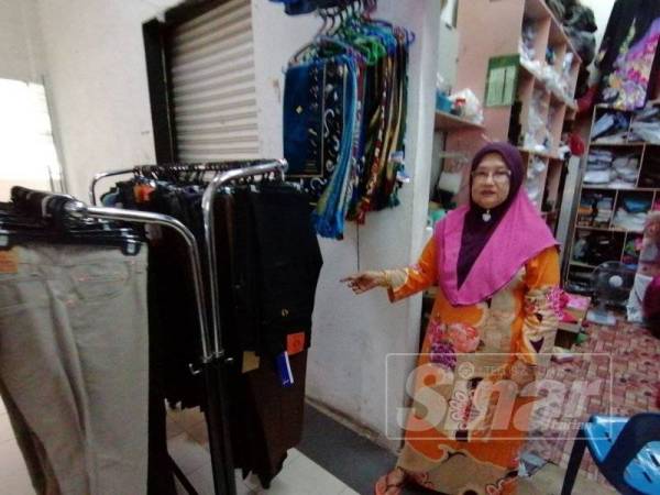 Fatimah menunjukkan laluan seorang lelaki berjalan keluar dari premisnya di Pasar Besar Kuala Berang, Hulu Terengganu sebelum didapati beg duitnya hilang.