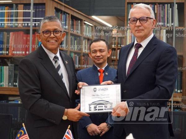 Maszlee (tengah), Hassan Basri (kiri) dan Stuart menunjukkan MoU yang dimeterai antara UnizSZA dan Durham University.