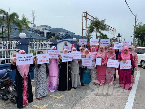 Marzuani (tiga dari kanan) bergambar bersama lebih 30 anggota Puteri UMNO dan ketua-ketua puteri bahagian di depan Ibu Pejabat Polis Daerah (IPD) Kota Bharu di sini.