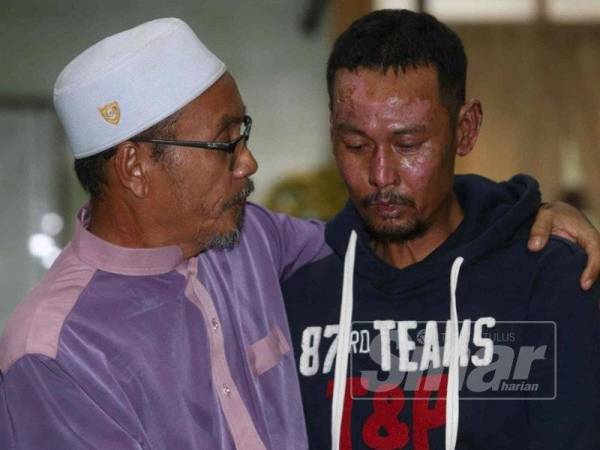 Abdul Rahim (kiri) menenangkan Hairol yang sebak menerima sumbangan hasil kutipan orang ramai.