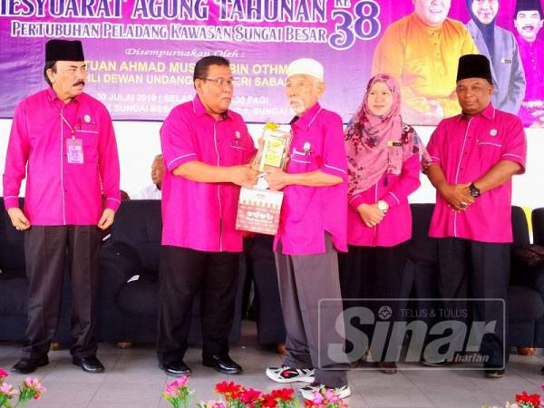 Ahmad Mustain (tiga dari kiri) menyampaikan sumbangan pada Mesyuarat Agung Tahunan Pertubuhan Peladang Kawasan Sungai Besar ke 38 di Dataran PPK Sungai Besar, Jalan Parit 1, di sini hari ini.