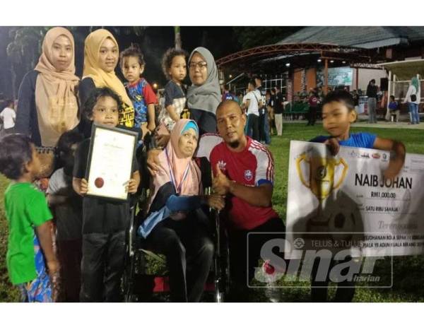 Mohd Azlan di samping keluarga dan ibunya, Saini yang sanggup hadir memberi sokongan kepadanya sewaktu perlawanan akhir kejohanan bola sepak Piala ADUN Kuala Berang di Padang Astaka Kuala Berang malam kelmarin.