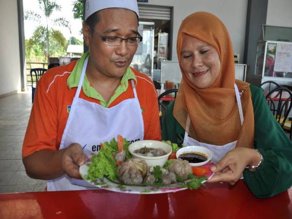 Helmy Abd Rashid, 48, (kiri) bersama isterinya Rosmawati Ghazali, 47, menunjukkan bakso citarasa durian yang direkanya dari cetusan idea kreatif di gerainya di Pasar Tani Kekal (PTK) Nyiur Tujuh bagi memenuhi selera peminat durian seiring dengan musim durian sekarang.
Helmy yang berpengalaman selama 20 tahun menjual bakso telah memberanikan diri dengan menggabungkan makanan berasal dari Indonesia itu bersama raja buah yang nyata mendapat sambutan peminat tempatan.
Beliau meemperkenalkan bakso digerainya dalam tiga versi iaitu isi durian digaul dengan bebola daging, isi durian disaluti isi daging dan isi durian segar dihidangkan bersama sup bakso.
Helmy juga berjaya mencipta 13 jenis rempah bagi menghasilkan rasa sup yang asli dan enak.- Foto Bernama 