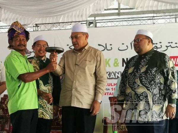 Ahmad (dua dari kanan) tertarik dengan gasing yang dipersembahkan sempena Hari Peladang, Penternak dan Nelayan Negeri Kelantan di Pantai Bisikan Bayu hari ini.