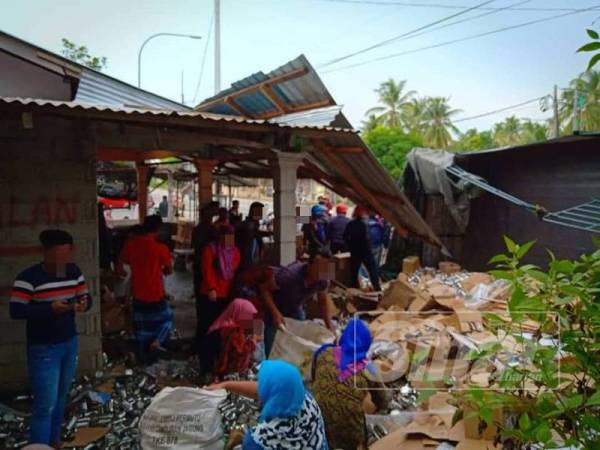 Orang ramai mengambil susu dari lori terbalik di Bachok semalam.