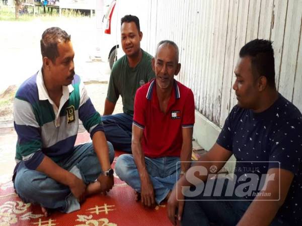 Abd Rahim (dua dari kanan) diziarahi keluarga dan penduduk kampung di rumahnya di Kampung Baru, Kuala Abang, Dungun hari ini selepas insiden menimpa anaknya.