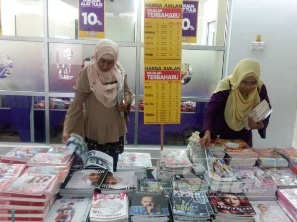 Dua guru daripada Sekolah Menengah Bandar Baru Sungai Buloh sedang memilih bahan bacaan untuk pusat sumber sekolah mereka.