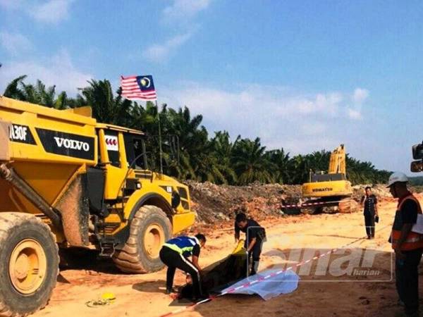 Polis sedang mengangkat mayat mangsa.