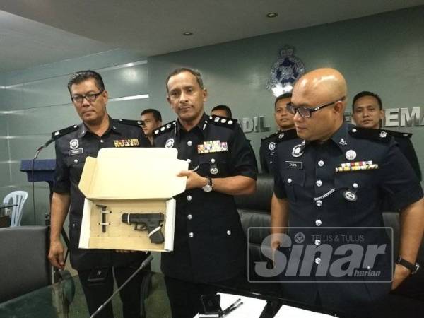 Mohamad Noor (tengah) menunjukkan pistol tiruan yang digunakan suspek ketika ditemui (IPD) Kuantan di sini hari ini.