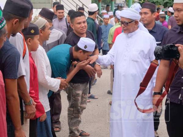 Abdul Hadi bersalaman dengan orang ramai selepas kuliah Dhuha di Masjid Rusila hari ini.